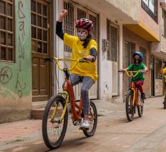 Children biking in line on streets of Calle Colombia.