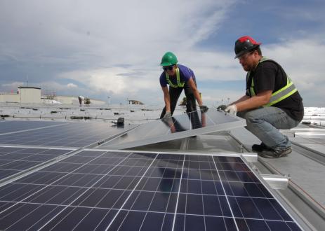 Woman and man installing a solar panel