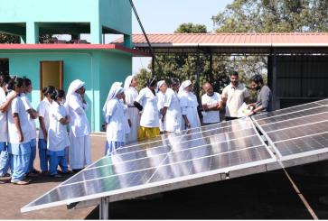 Healthcare workers near solar panel in India